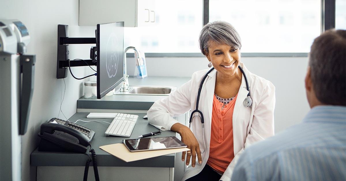 image shows female doctor talking to patient in the office