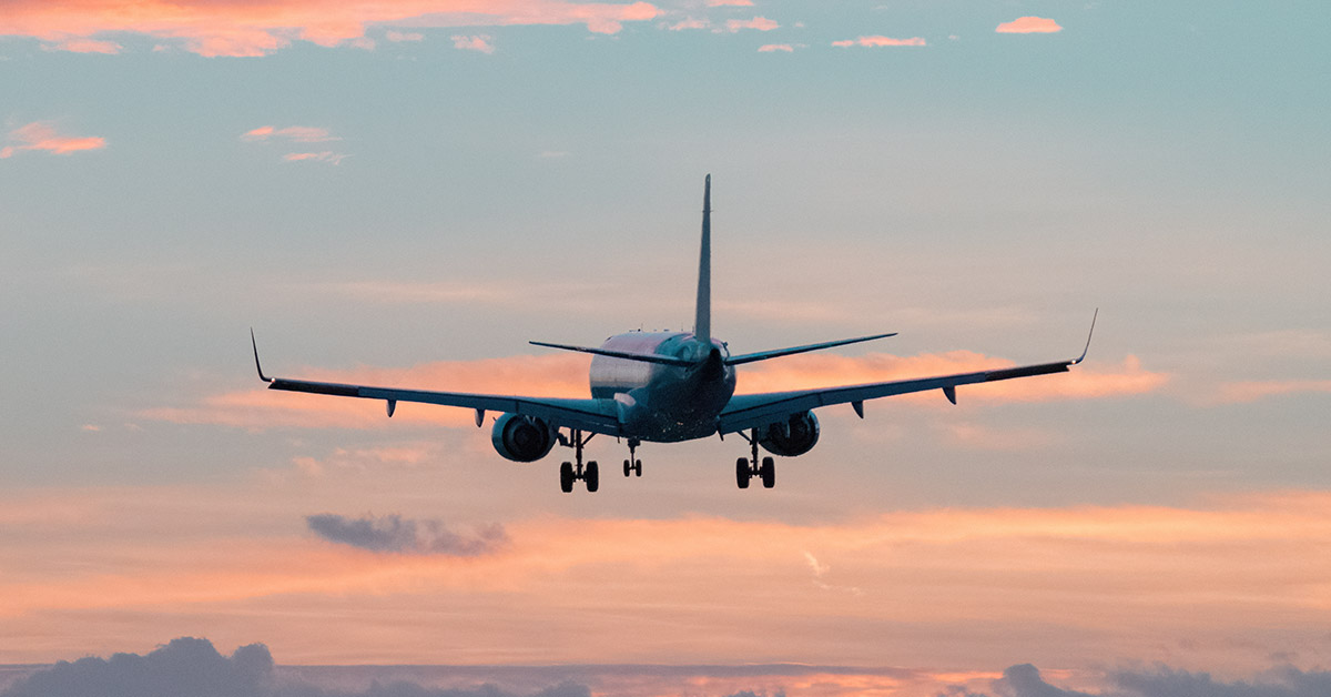 plane in the sky with colorful clouds