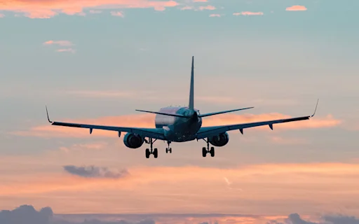 plane in the sky with colorful clouds