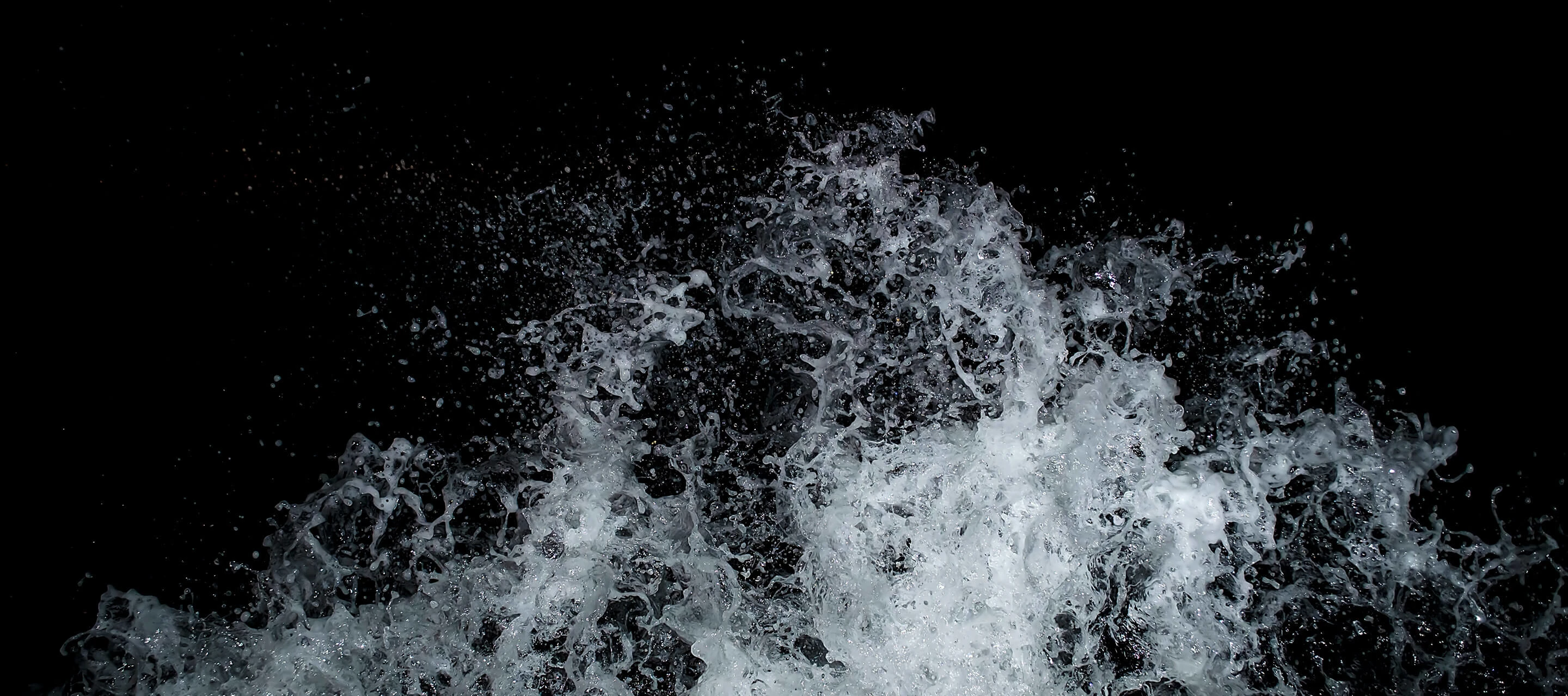 image shows wave splashing against black background