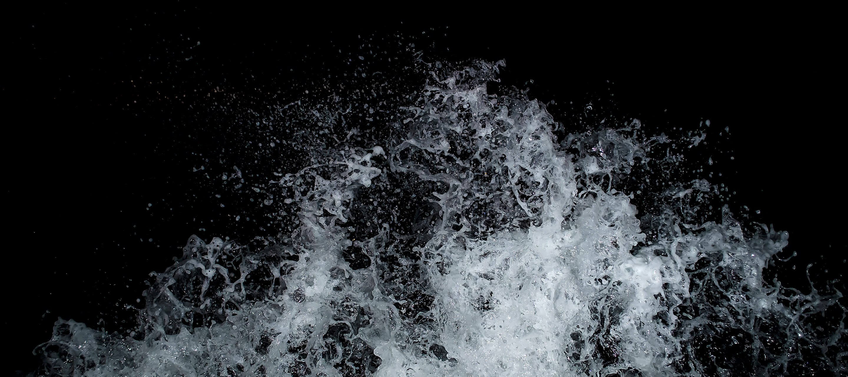image shows wave splashing against black background 
