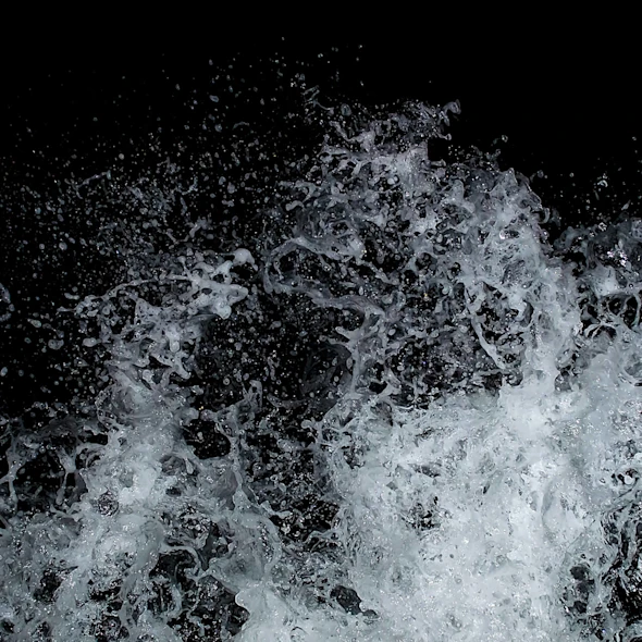 image shows wave splashing against black background