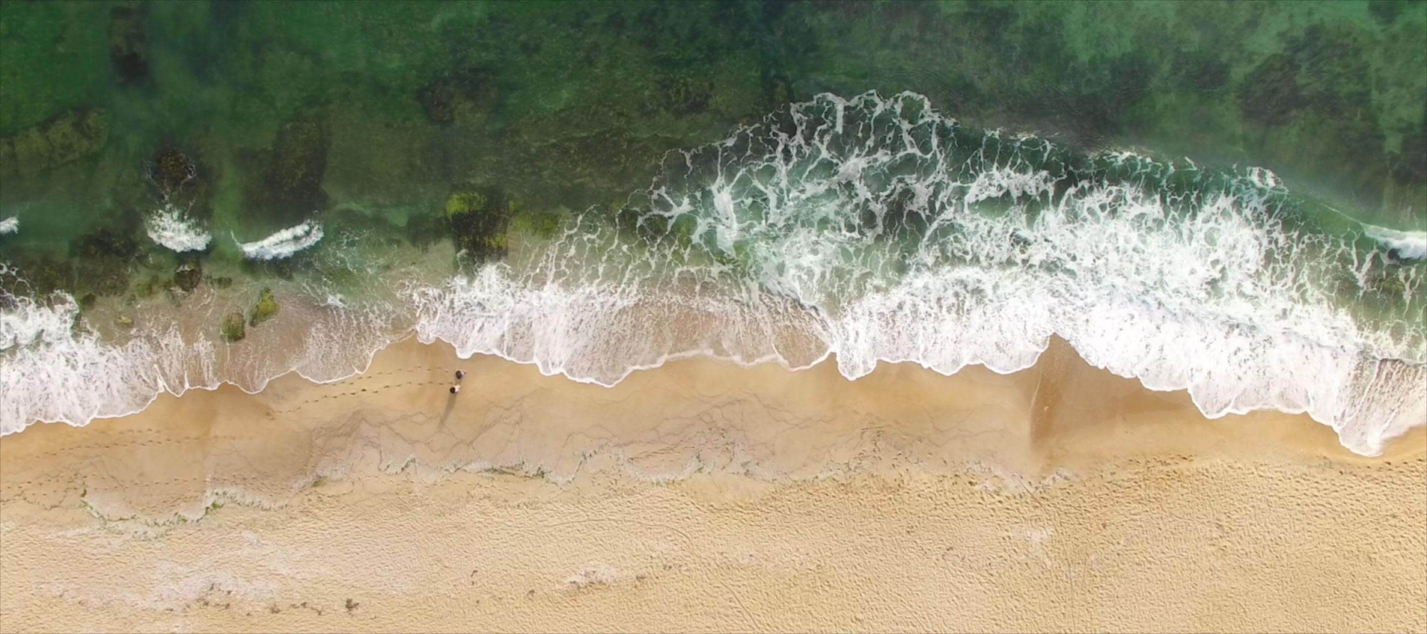 green waves meeting the sand