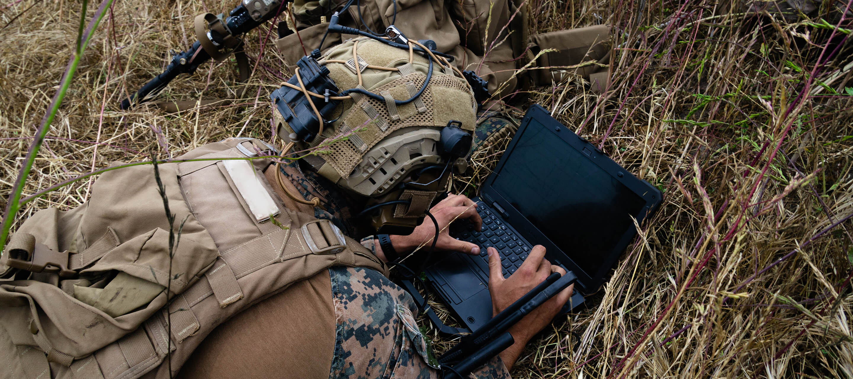 soldier on the ground looking at computer