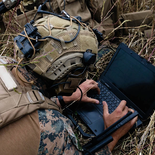 soldier on the ground looking at computer