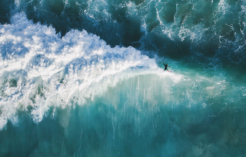 surfer riding blue waves