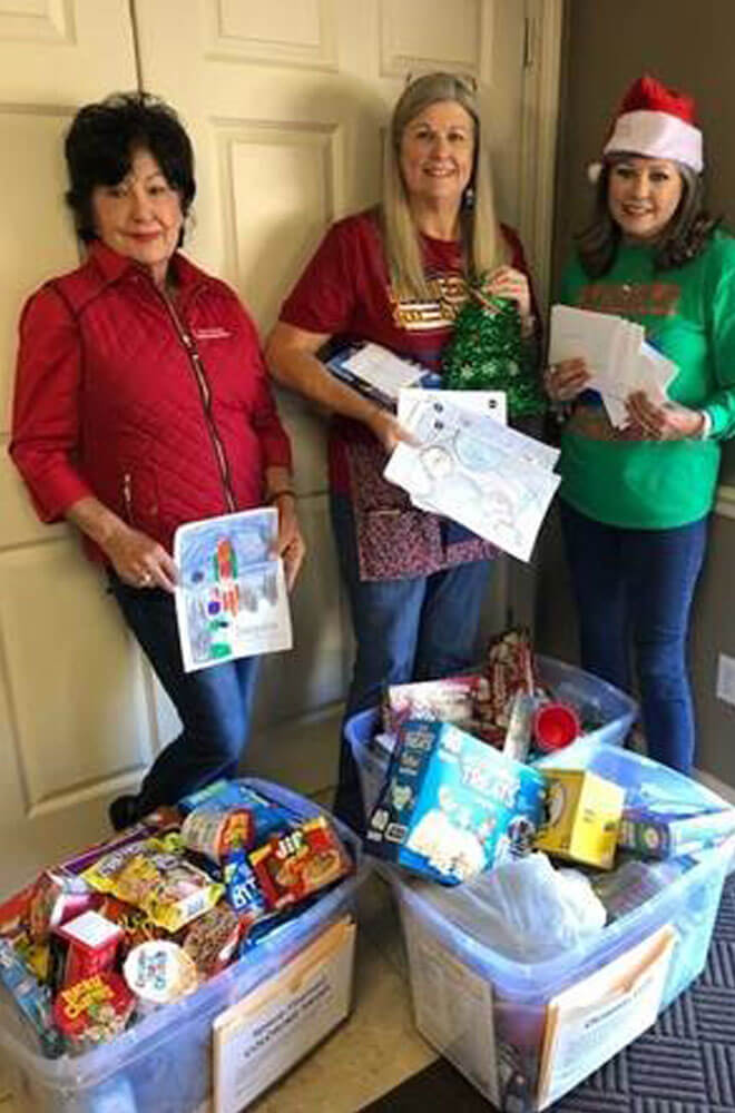 3 people standing next to donations