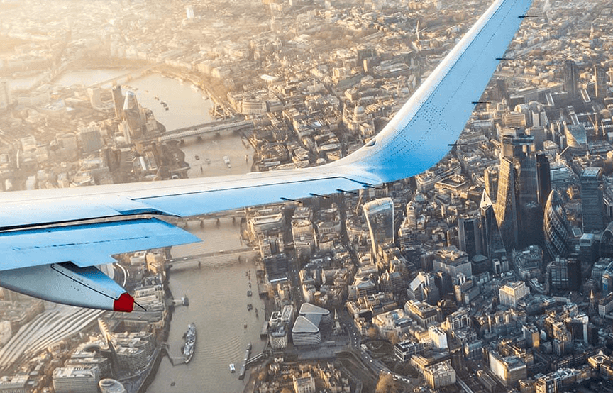 airplane wing over the city sky