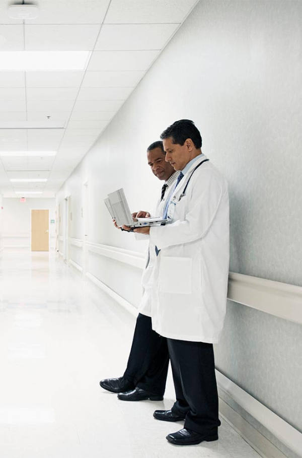 two doctors standing in white hallway