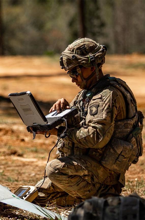 soldier on the ground looking at the computer