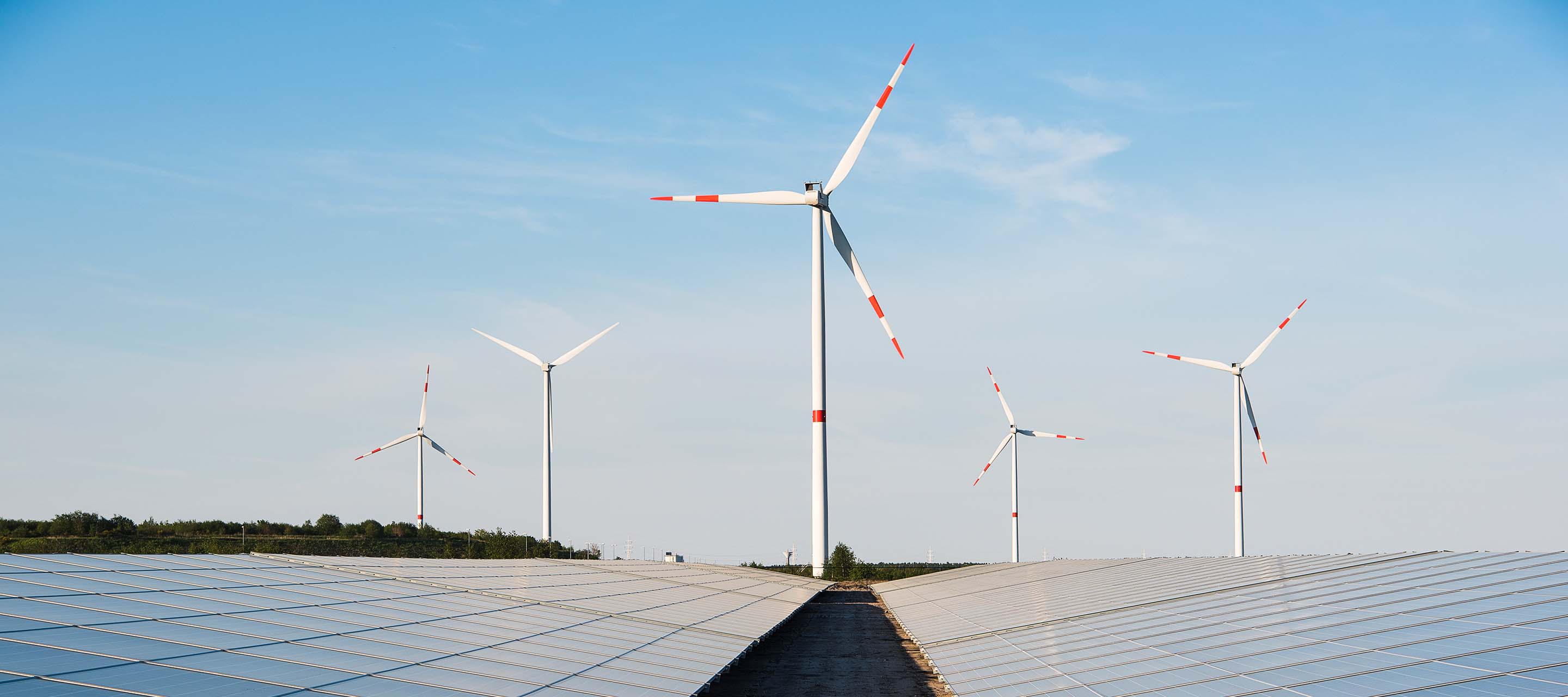 windmills and solar panels with blue skies 