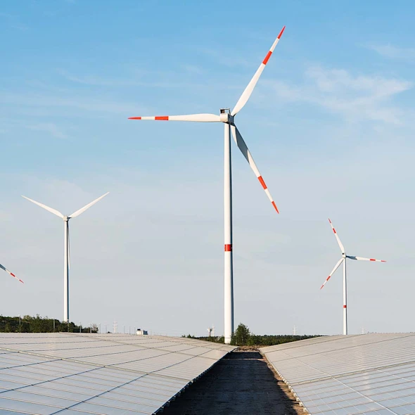 windmills and solar panels with blue skies