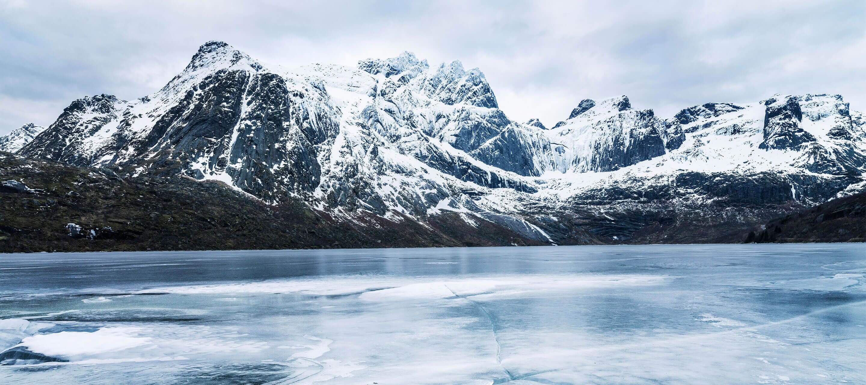 snowy mountains overlooking a frozen lake