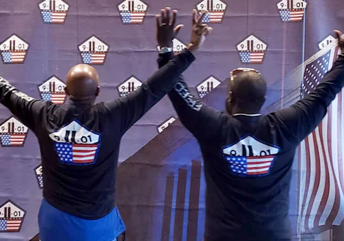 two people standing with this arms raised