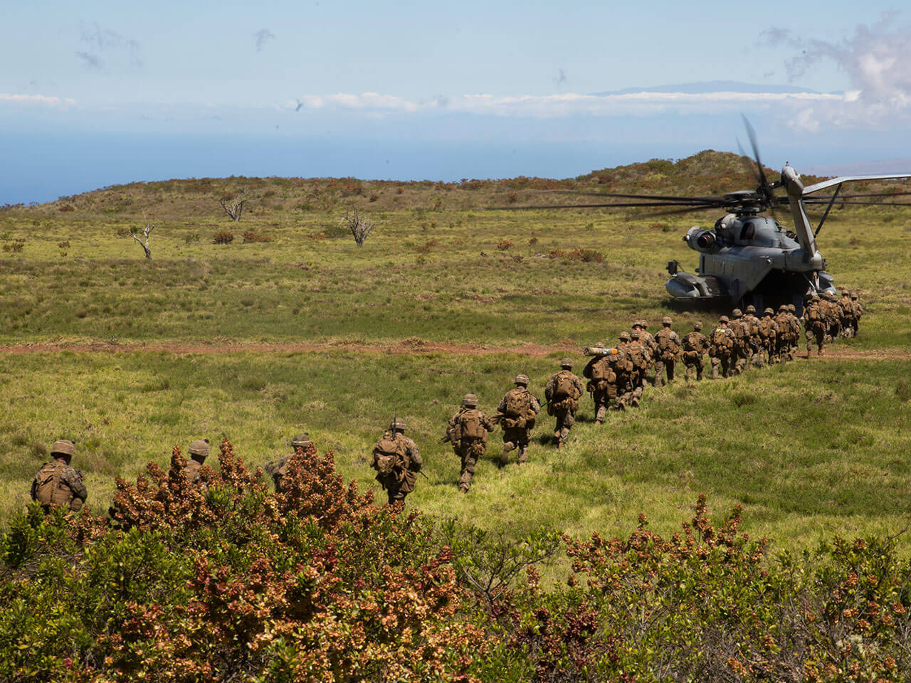 soldiers marching towards a helicopter 