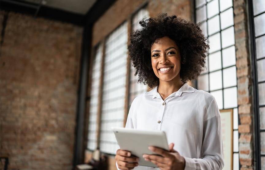 woman holding a tablet smiling at the camera