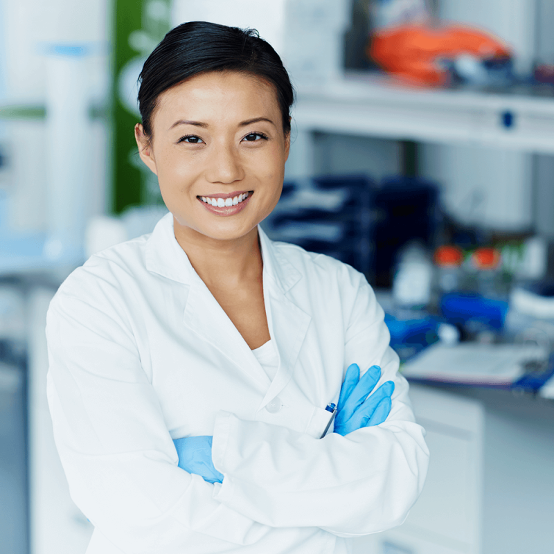 scientist with white lab coat and blue sterile gloves