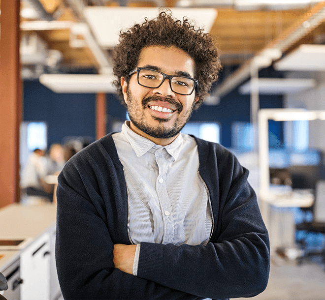 young man smiling with his arms crossed