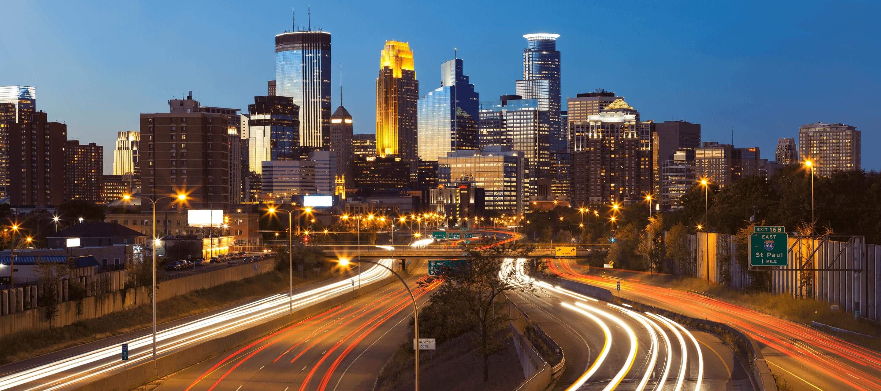 city with lit up roads from cars driving