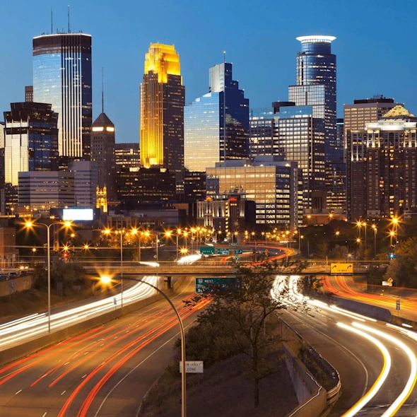 city with lit up roads from cars driving