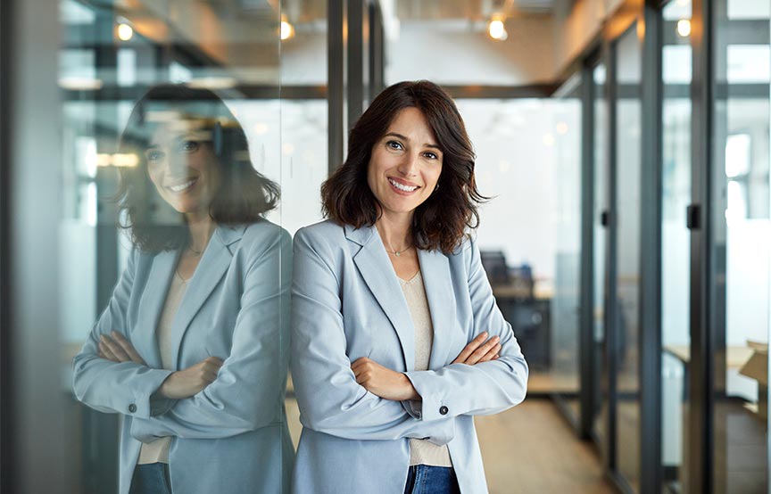 woman in office, smiling with arms crossed