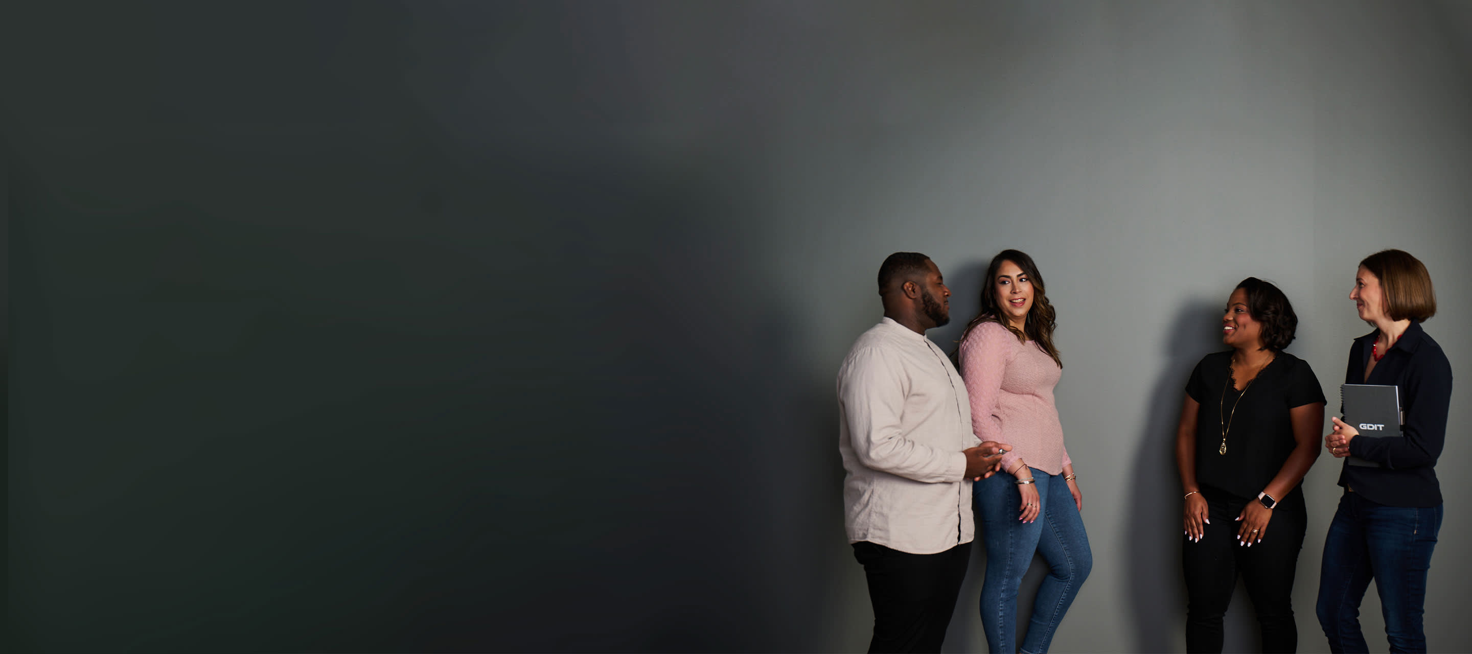 colleagues standing together by grey wall