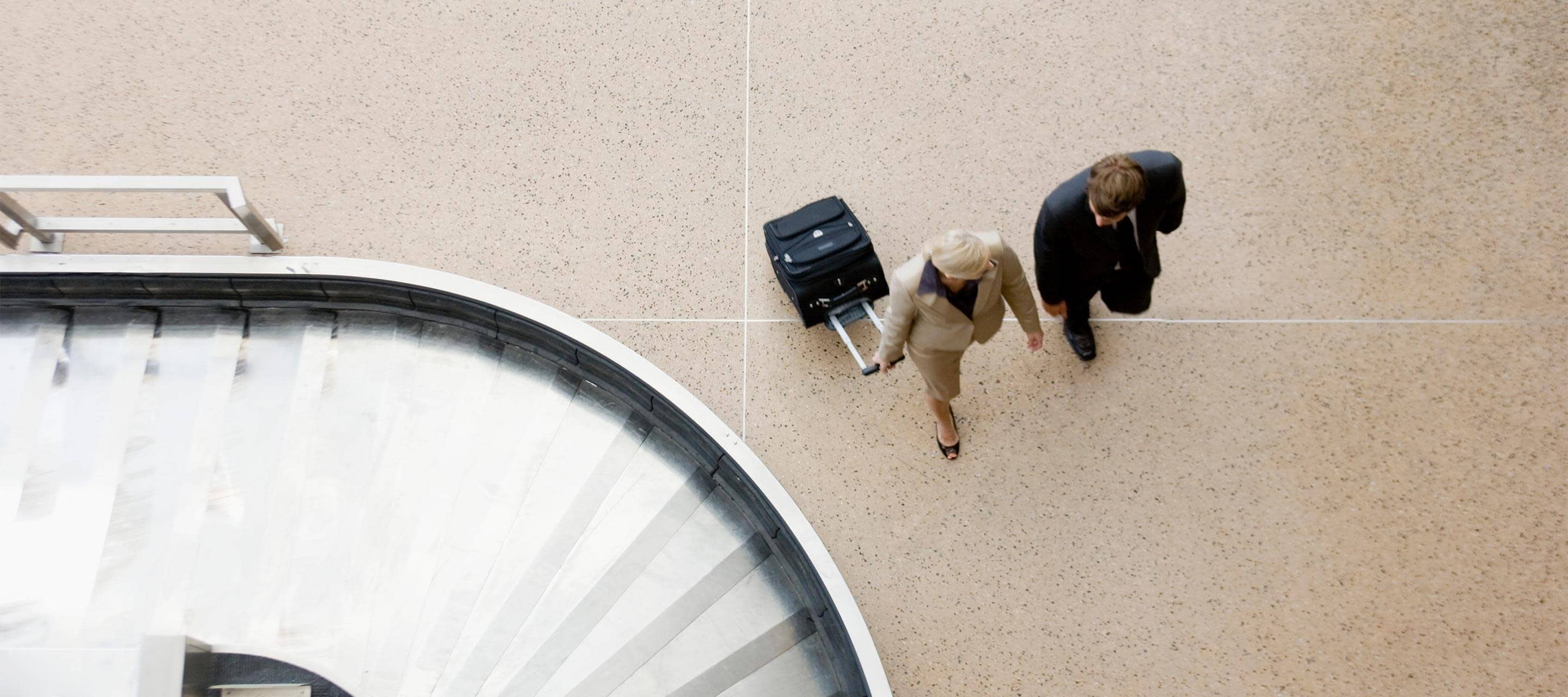 aerial view of two people walking through airport 