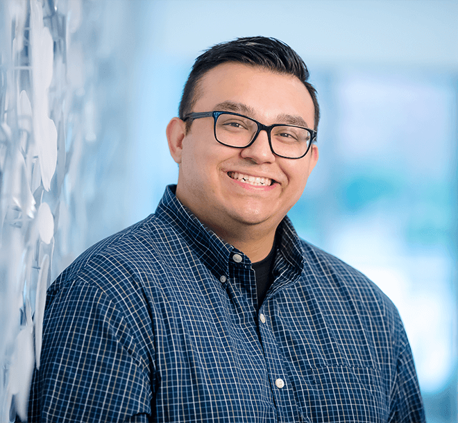 smiling man in glasses and blue bottom down shirt
