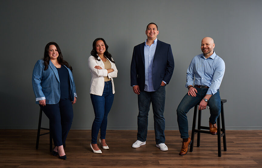 employees standing together by grey wall