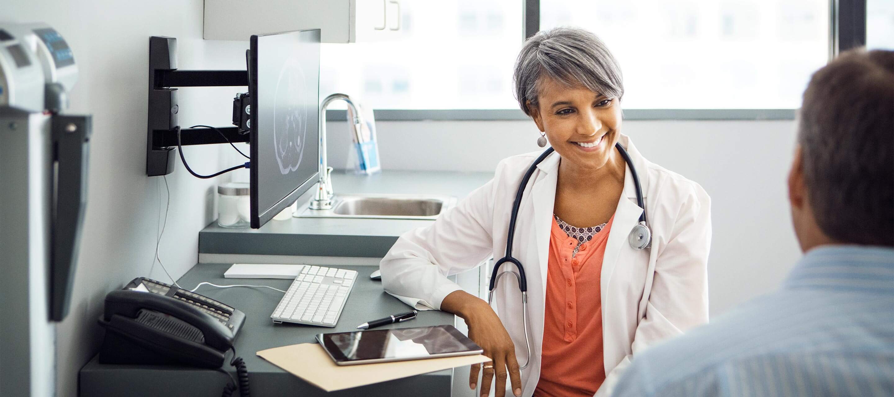 image shows female doctor talking to patient in the office