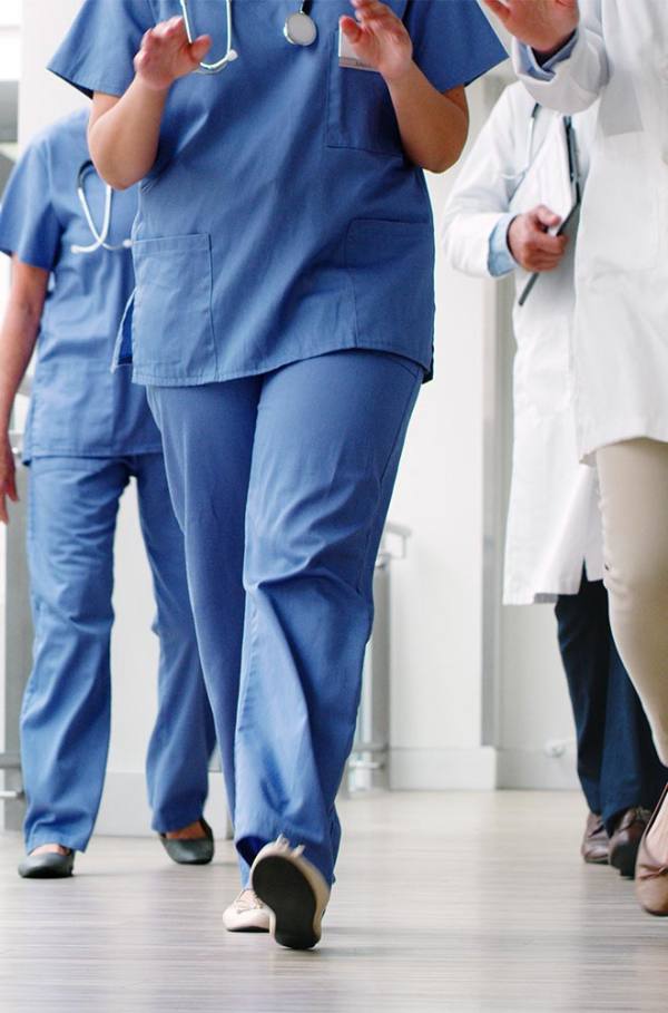 image shows legs of nurse in scrubs walking 