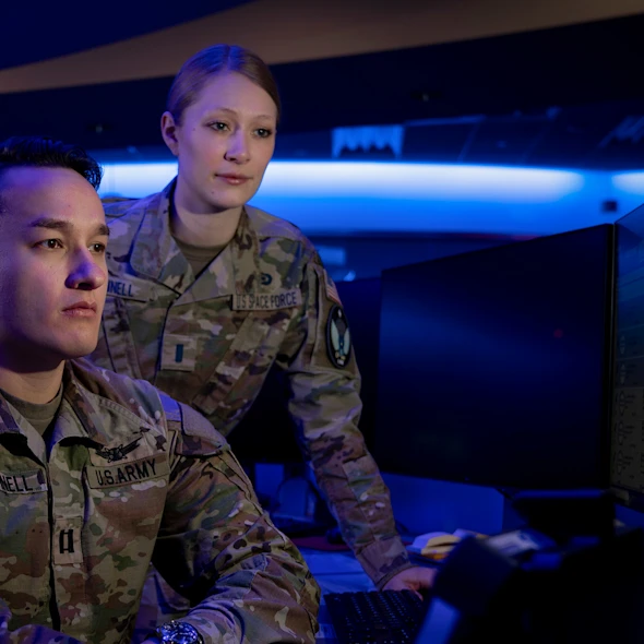 two soldiers looking at a computer