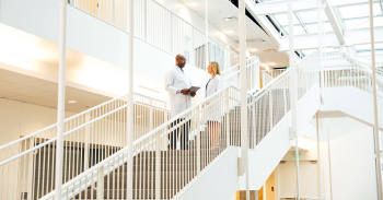image shows two doctors talking to one another at stairs
