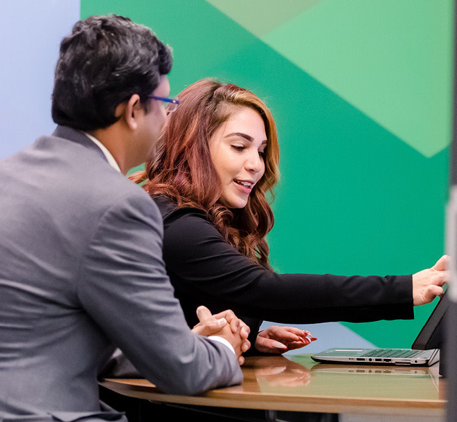 Two people looking at a laptop