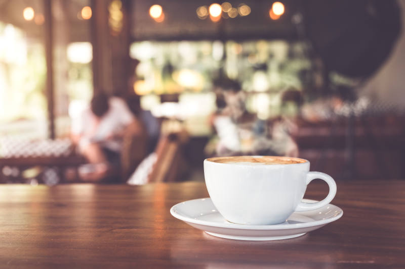 Cup of coffee on a table, blurred background of coffeehouse