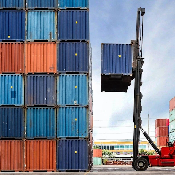 forklift surrounded by orange and blue shipping containers