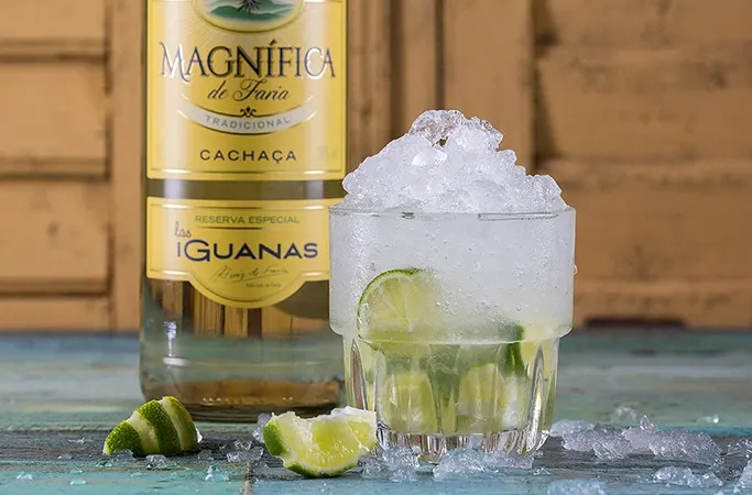 Caipirinha cocktail next to a bottle of Las Iguanas Magnifica Cachaca