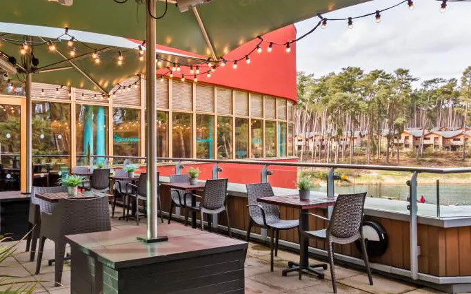 Tables on terrace overlooking lake at Las Iguanas Center Parcs Woburn