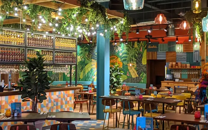 Brightly coloured interior of Las Iguanas Plymouth with murals and hanging plants