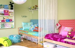 Ljust barnrum med vita gardiner, två sängar i grönt och rosa, färgglada kuddar, puff, leksakshylla