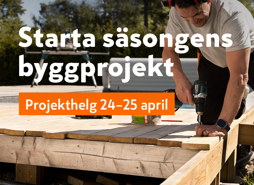 Man borrar träplankor utomhus under orange och lila banner med projekthelg 24-25 april