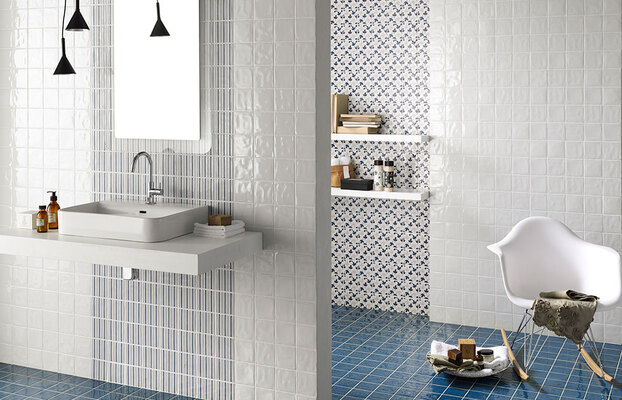 Modernt badrum med vita väggplattor, blått klinkergolv, flytande handfat och svarta hänglampor