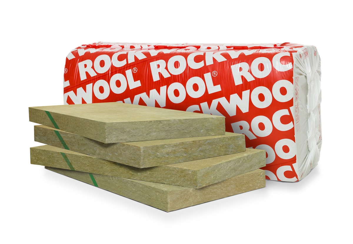 Rödrött Rockwool-paket bakom staplade gula stenullsskivor med gröna remsor.