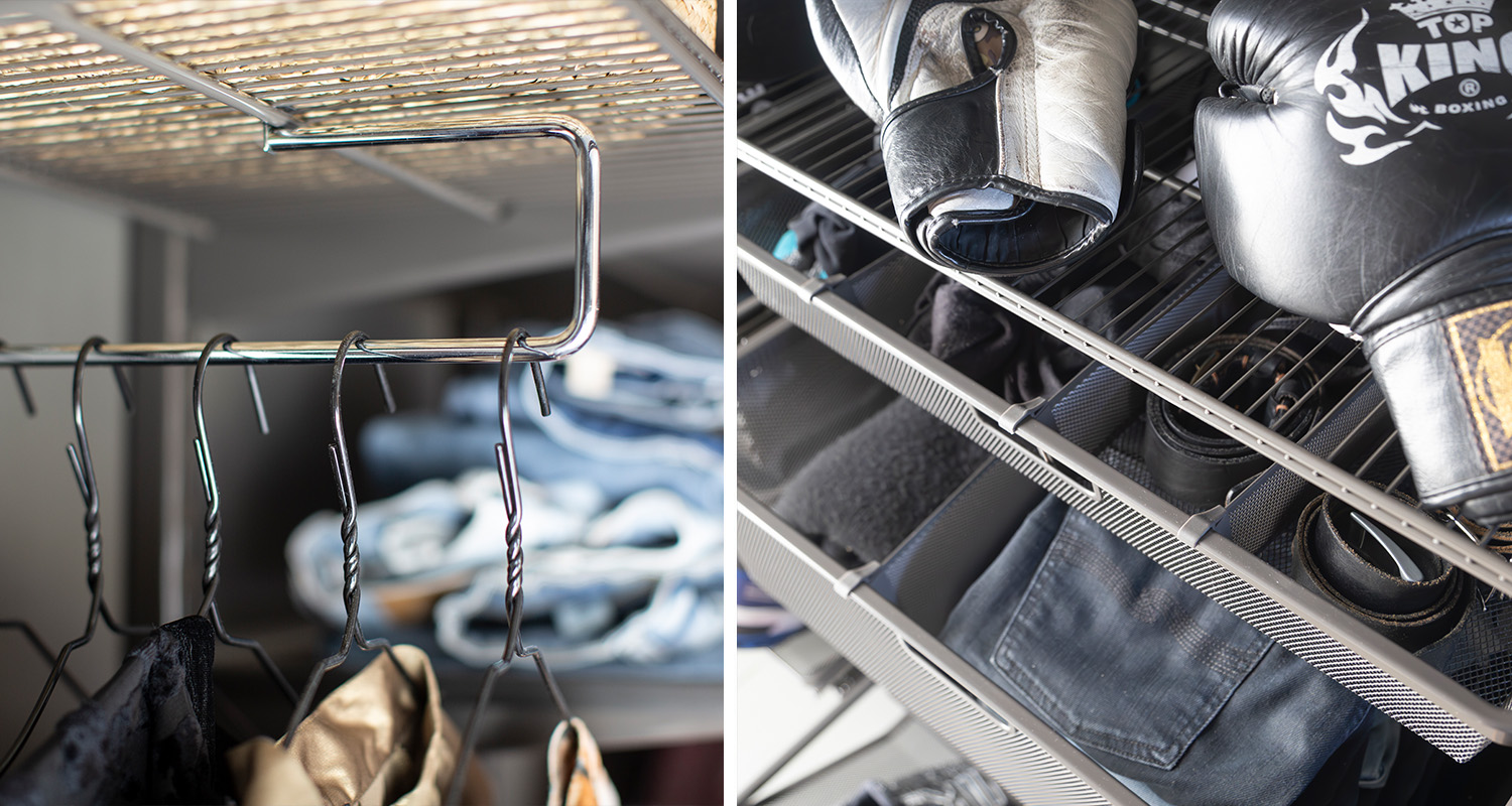 Grått metallgarderobssystem med svarta vridna galgar, jeans och boxningshandskar