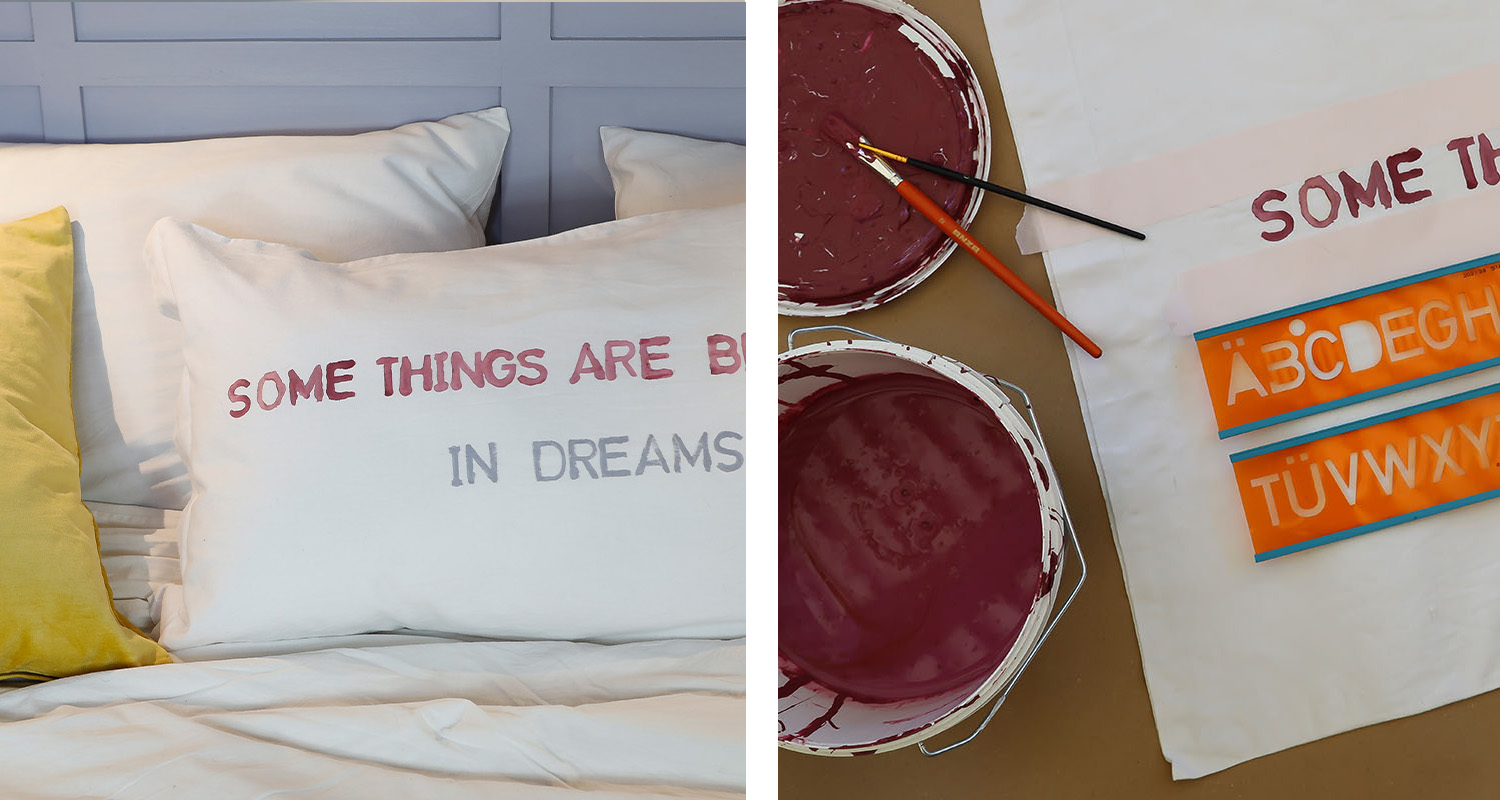 Vit kudde med texten 'Some things are better in dreams', bredvid röd färgburk och alfabetstenciler
