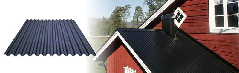 Svart korrugerad takplåt bredvid röd stuga med svart tak och skog i bakgrunden.