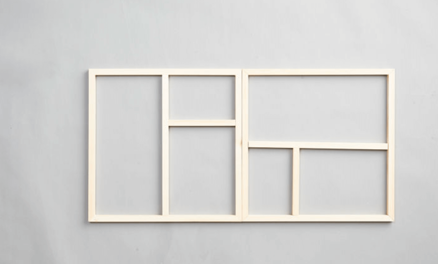 Omålad träram med sex fält i olika storlekar på ljusgrå vägg