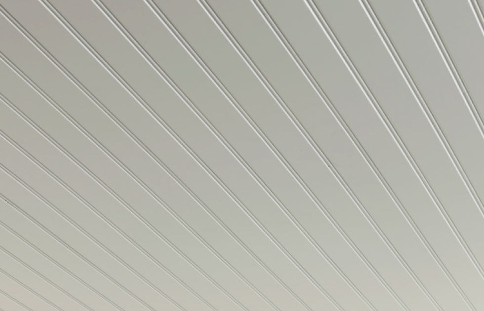 Ljusgrå-beige takpanel med tunna parallella ränder i perspektiv.