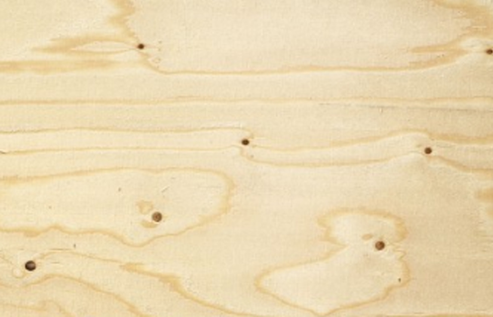 Ljust beige plywoodskiva med tydlig ådring och mörka knutar.