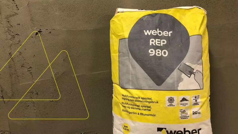 Gul och grå säck med Weber REP 980 spackel framför en nyligen putsad grå vägg